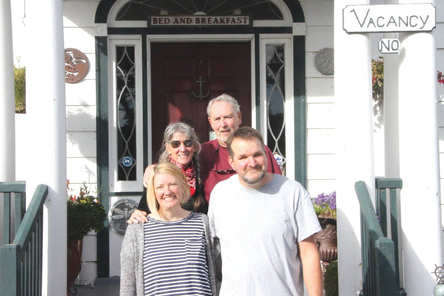 Natalie Dionne, Gail Oldroyd, Jim Oldroyd and David Dionne stand at the front steps to the Commander’s Beach House, a bed-and-breakfast located on the water at Point Hudson.